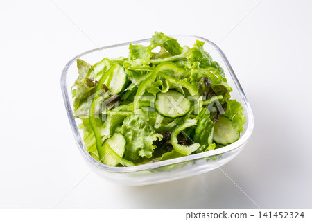 Green salad with bell peppers and cucumbers, against a white background. 141452324