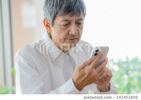 A man who uses a smartphone A man who uses a smartphone 141452850