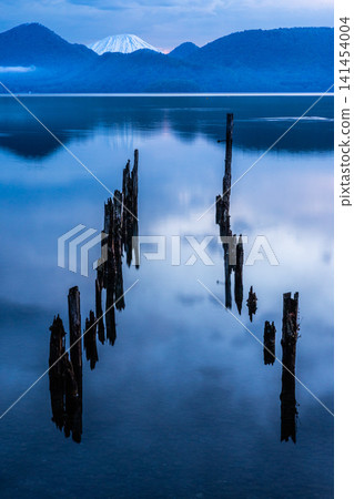 The remains of a pier on Lake Toya on a spring morning. The remains of a pier on Lake Toya on a spring morning. 141454004