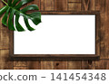 A dark oak whiteboard with shelves, adorned with monstera leaves. 141454348