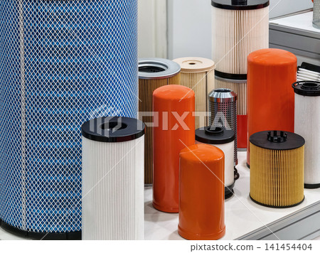 Different types of filters are displayed on a table at an industrial exhibition in a bright room 141454404