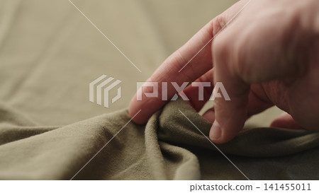 man hand checking green cotton jersey cloth man hand checking green cotton jersey cloth 141455011