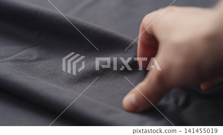 man hand checking blue cotton jersey cloth man hand checking blue cotton jersey cloth 141455019