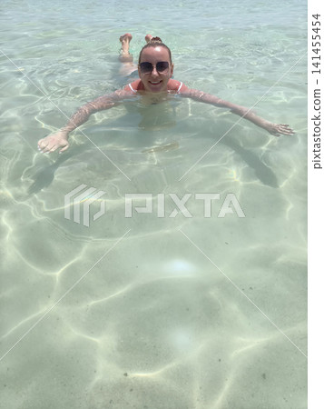 woman glides effortlessly through clear sea waters, her arms stretched wide graceful swimming pose, capturing thrill aquatic adventure, the purity ocean joy embracing an active, sun soaked lifestyle woman glides effortlessly through clear sea waters, her arms stretched wide graceful swimming pose, capturing thrill aquatic adventure, the purity ocean joy embracing an active, sun soaked lifestyle 141455454