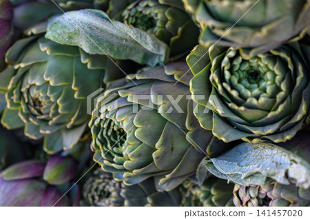 Exploring the intricate beauty of artisanal artichokes at dawn in a vibrant farmer's market Exploring the intricate beauty of artisanal artichokes at dawn in a vibrant farmer's market 141457020