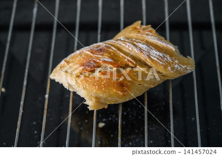 Freshly baked croissant cooling on a wire rack in a cozy kitchen setting Freshly baked croissant cooling on a wire rack in a cozy kitchen setting 141457024