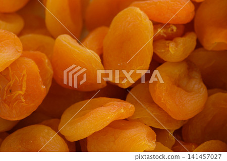 Sweet and tangy dried apricots piled high in a vibrant display at a bustling market in summer Sweet and tangy dried apricots piled high in a vibrant display at a bustling market in summer 141457027