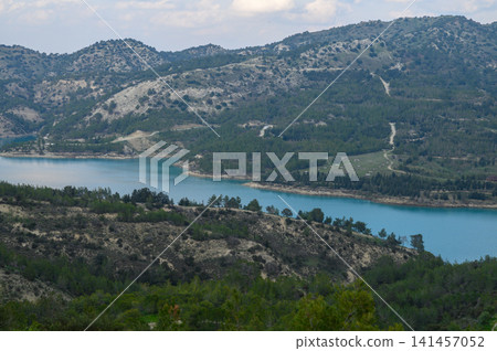 Breathtaking landscape with serene blue lake surrounded by lush greenery and rugged mountains in the Breathtaking landscape with serene blue lake surrounded by lush greenery and rugged mountains in the 141457052