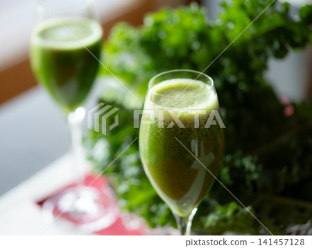 Fresh organic kale smoothie with kale leaves in background. Fresh organic kale smoothie with kale leaves in background. 141457128