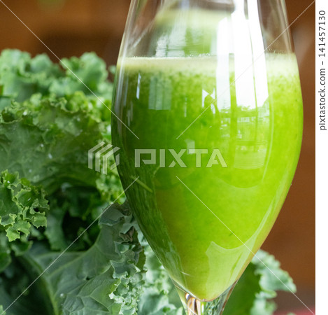 Fresh organic kale smoothie with kale leaves in background. Fresh organic kale smoothie with kale leaves in background. 141457130