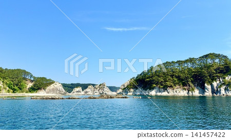 Jodogahama Beach (Miyako City, Iwate Prefecture) is adorned with a blue sky, fresh green pine trees, a cluster of white rhyolite rock formations, and emerald blue water. Jodogahama Beach (Miyako City, Iwate Prefecture) is adorned with a blue sky, fresh green pine trees, a cluster of white rhyolite rock formations, and emerald blue water. 141457422