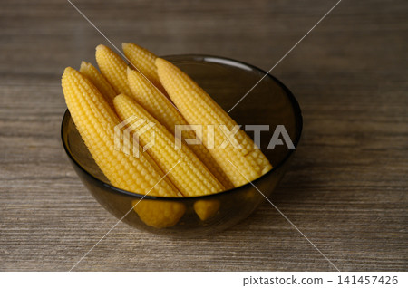 Fresh and vibrant baby corn arranged beautifully in a stylish bowl ready for a colorful dish in a cozy kitchen setting Fresh and vibrant baby corn arranged beautifully in a stylish bowl ready for a colorful dish in a cozy kitchen setting 141457426