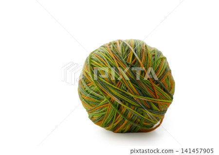 Colorful yarn ball resting on a white surface with a soft, inviting glow, perfect for a cozy knitting or crafting session Colorful yarn ball resting on a white surface with a soft, inviting glow, perfect for a cozy knitting or crafting session 141457905