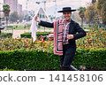 Portrait of a smiling, cheerful young man dressed as a Chilean huaso, celebrating and posing to dance cueca, a traditional Chilean dance. Chilean traditions, celebration, and culture. 141458106
