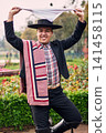 Portrait of a smiling, cheerful young man dressed as a Chilean huaso, celebrating and posing to dance cueca, a traditional Chilean dance. Chilean traditions, celebration, and culture. 141458115