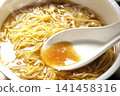 Scoop the soup from the cup noodles with a spoon. 141458316