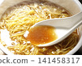 Scoop the soup from the cup noodles with a spoon. 141458317