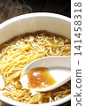 Scoop the soup from the cup noodles with a spoon. 141458318