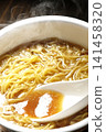 Scoop the soup from the cup noodles with a spoon. 141458320