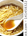 Scoop the soup from the cup noodles with a spoon. 141458322