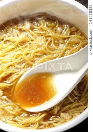 Scoop the soup from the cup noodles with a spoon. Scoop the soup from the cup noodles with a spoon. 141458322