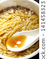 Scoop the soup from the cup noodles with a spoon. 141458323
