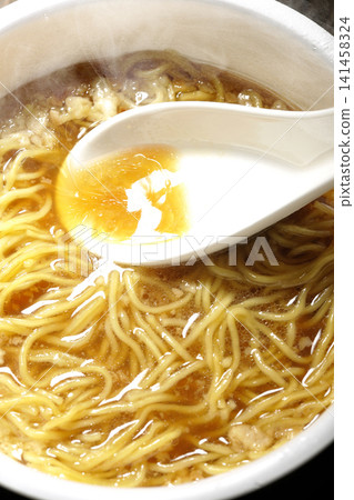 Scoop the soup from the cup noodles with a spoon. Scoop the soup from the cup noodles with a spoon. 141458324