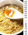 Scoop the soup from the cup noodles with a spoon. 141458326