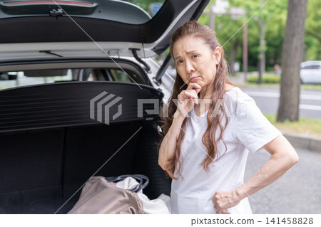 Senior woman and car cargo area trouble Senior woman and car cargo area trouble 141458828