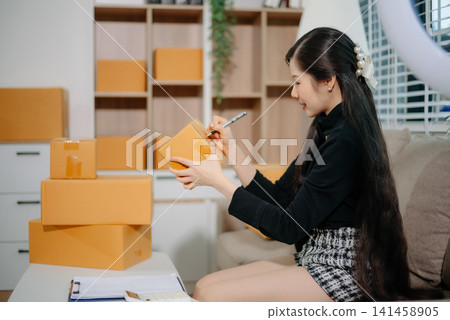 Small business entrepreneur SME freelance woman working at home office, BOX,tablet and laptop online, marketing, packaging Small business entrepreneur SME freelance woman working at home office, BOX,tablet and laptop online, marketing, packaging 141458905