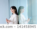 Profile of a woman holding a smartphone 141458945