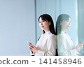 Profile of a woman holding a smartphone 141458946