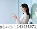 Woman operating a smartphone 141458971