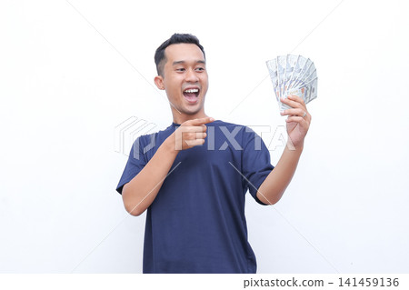 Man beams joyfully, flexing arm proudly. He holds money in one hand, smiling widely. Studio lighting highlights his enthusiastic expression. Perfect for business, finance, or success-themed projects Man beams joyfully, flexing arm proudly. He holds money in one hand, smiling widely. Studio lighting highlights his enthusiastic expression. Perfect for business, finance, or success-themed projects 141459136