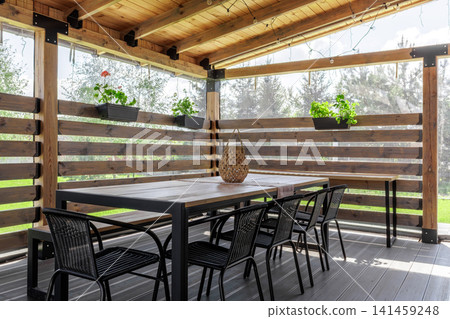 Covered Wooden Terrace with Dining Set and Plants Covered Wooden Terrace with Dining Set and Plants 141459248