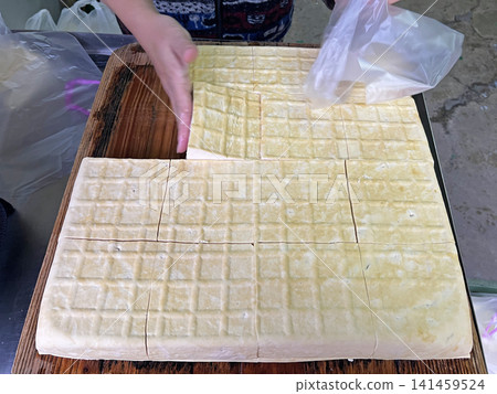 The video shows a traditional tofu shop where staff skillfully pack tofu into plastic bags and sell it to customers. The video shows a traditional tofu shop where staff skillfully pack tofu into plastic bags and sell it to customers. 141459524