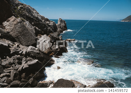 Rocky Coastline with Waves Crashing Against the Shore 141459572