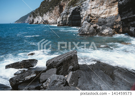 Rocky Coastline with Waves Crashing Against Cliffs Rocky Coastline with Waves Crashing Against Cliffs 141459573
