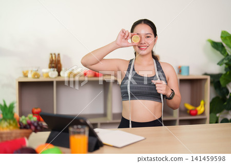 Asian woman holding orange slice over eye for healthy lifestyle concept Asian woman holding orange slice over eye for healthy lifestyle concept 141459598