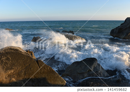 Sea stack on a pebble shore with incoming waves at sunset, Cyprus Sea stack on a pebble shore with incoming waves at sunset, Cyprus 141459682