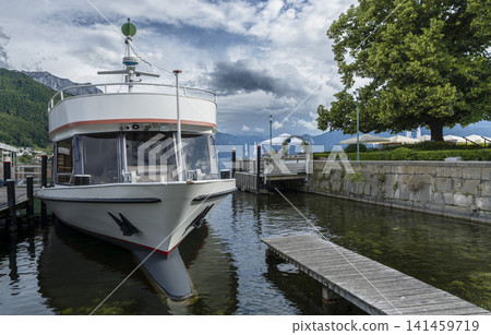 Boat on Lake Traunsee with a picturesque mountain landscape, illustrating European small town charm and peaceful waterfront life. Boat on Lake Traunsee with a picturesque mountain landscape, illustrating European small town charm and peaceful waterfront life. 141459719