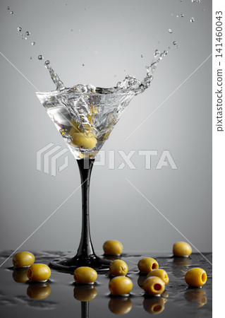 Martini with green olives on a wet table. Martini with green olives on a wet table. 141460043