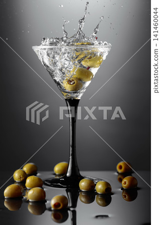Martini with green olives on a wet table. Martini with green olives on a wet table. 141460044