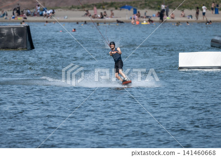 Cable Wakeboarder Riding on Lake in Summer Cable Wakeboarder Riding on Lake in Summer 141460668