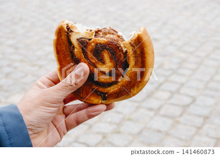 man eating a kanelsnegl in Copenhagen man eating a kanelsnegl in Copenhagen 141460873
