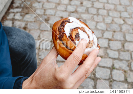 a man holds a traditional kanelsnegl in Copenhagen a man holds a traditional kanelsnegl in Copenhagen 141460874