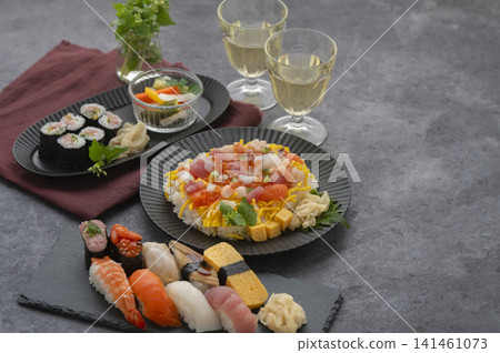豐盛的日式現代晚餐,包括握壽司和海鮮散壽司,佐以白酒。 豐盛的日式現代晚餐,包括握壽司和海鮮散壽司,佐以白酒。 141461073