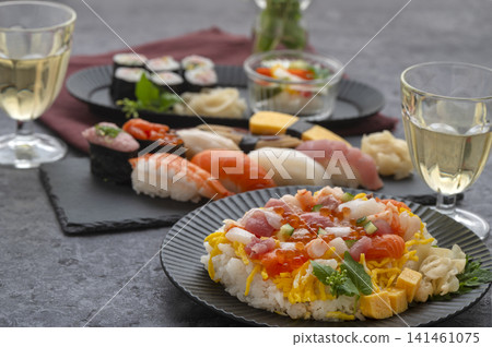 豐盛的日式現代晚餐,包括握壽司和海鮮散壽司,佐以白酒。 豐盛的日式現代晚餐,包括握壽司和海鮮散壽司,佐以白酒。 141461075