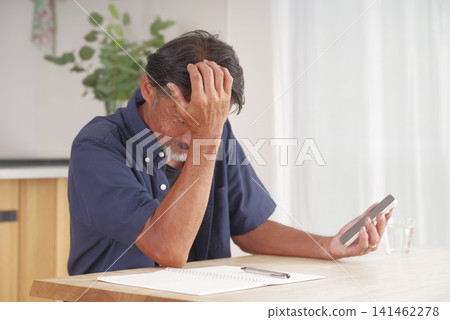 一名男子看到智慧型手機上的通知後感到震驚。 一名男子看到智慧型手機上的通知後感到震驚。 141462278
