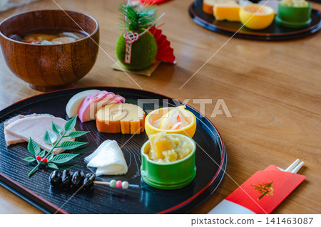 擺盤精美的御節料理（傳統新年食物）和味噌湯，也裝飾著新年飾品。 141463087